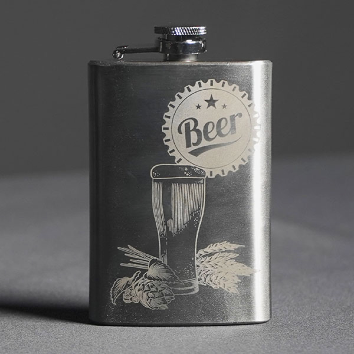 Metal flask engraved with beer illustration.